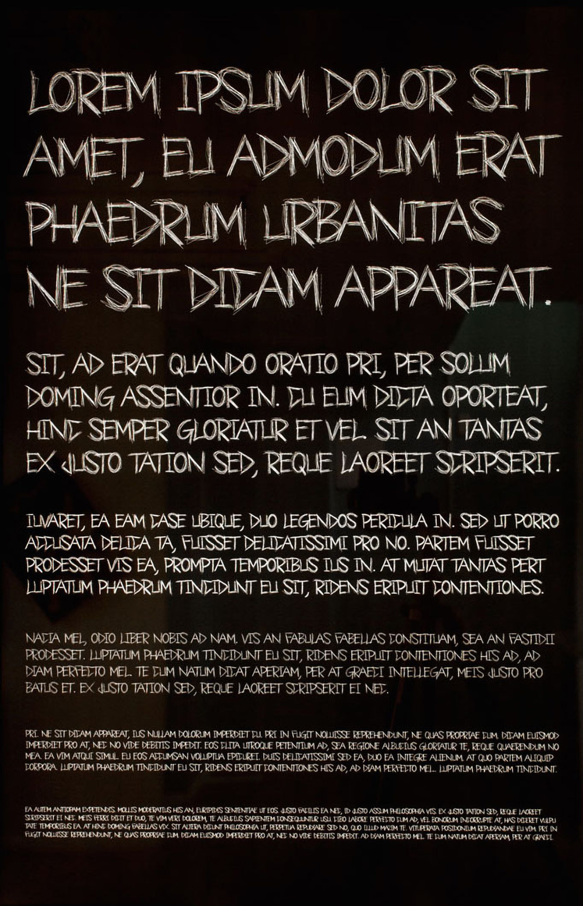Scratchy, white, all-caps text on a black ground. The text is in 6 paragraphs of descending sizes, all reading 'lorem ipsum' text.