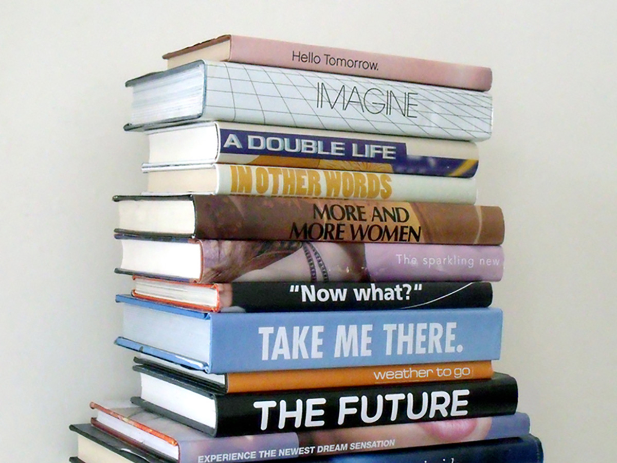 Photo of a stack of books. The names on their spines are arranged so that they read 'Hello tomorrow. Imagine a double life in other words more men and women the sparkling new "now what?" take me there. Weather to go the future experience the newest dream sensation'
