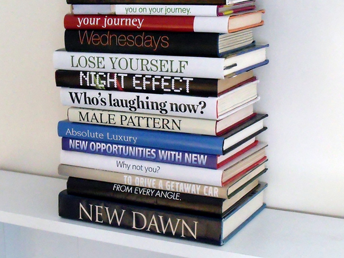 Photo of a stack of books. The names on their spines are arranged so that they read 'you on your journey. your journey. Wednesdays lose yourself night effect who's laughing now? MALE PATTERN absolute luxury new opportunities with new why not you? To drive a getaway car from every angle. NEW DAWN'